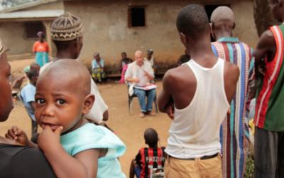 Der Epidemiologie Michel Van Herp von Ärzte ohne Grenzen (Bildmitte) erklärt der lokalen Bevölkerung in Gbando die Krankheit Ebola und wie man eine Ausbreitung des Virus vermeiden kann.