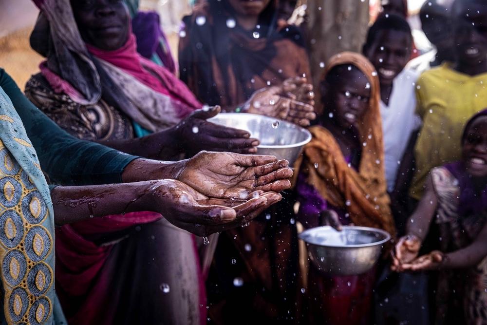 Women collecting water at the Adré transit camp distribution point, eastern Chad.