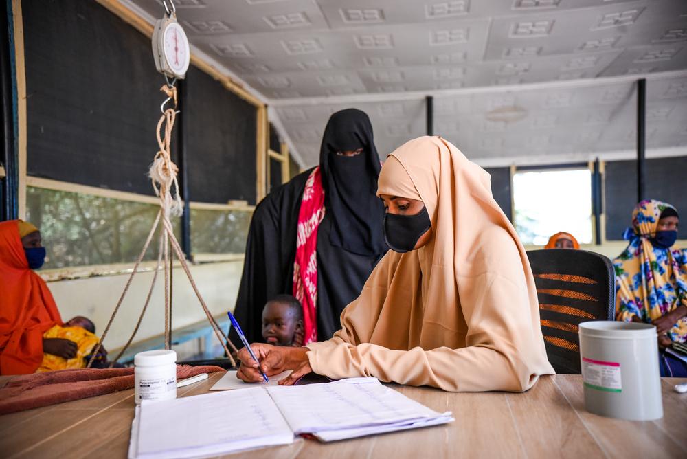 MSF staff records weight of a child brought to the health post for treatment