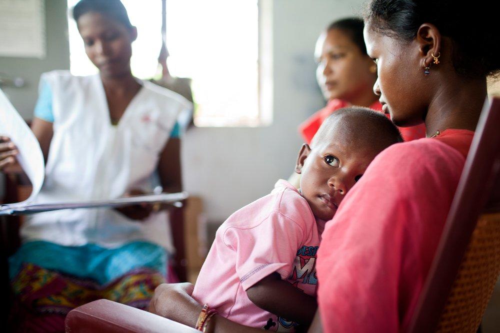 A mother and child sitting for a checkup at Pusalota health centre.