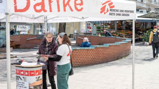 Unsere Kollegin Tabea führt ein Spendengespräch mit einer Passantin  am Infostand.