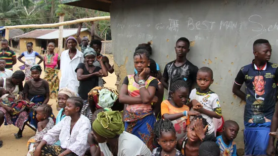  Das Dorf hat sich versammelt und hören dem Team aus Gesundheitspromotern interessiert zu.