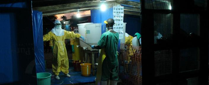 Medizinisches Personal bei der Desinfektion von Schutzkleidung im Ebola-Behandlungszentrum in Foya.