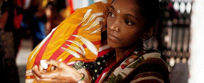 Indien 2011 Eine Mutter trägt ihr Baby und hält das Medikament in der Hand