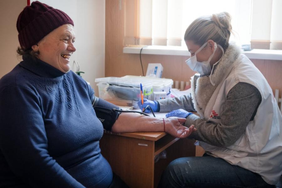 MSF doctor Olena Kurinna checking Anna Ivanivna Nefedova's blood pressure