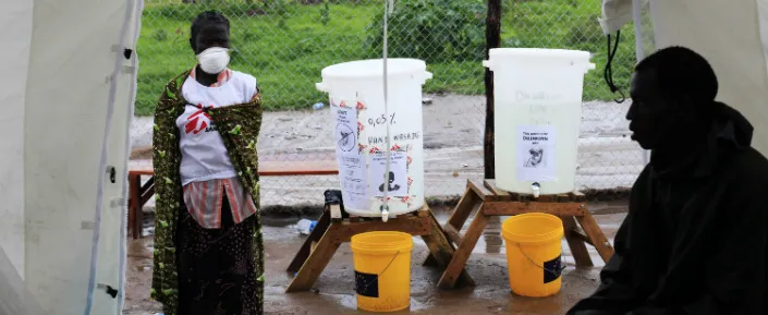 Ein Mitarbeiter von Ärzte ohne Grenzen vor einem Zelt für die Neuaufnahme von PatientInnen in das Cholera-Behandlungszentrum in Juba