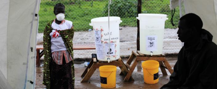 Ein Mitarbeiter von Ärzte ohne Grenzen vor einem Zelt für die Neuaufnahme von PatientInnen in das Cholera-Behandlungszentrum in Juba