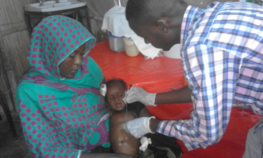 White Nile State, Sudan, Doctor examines child