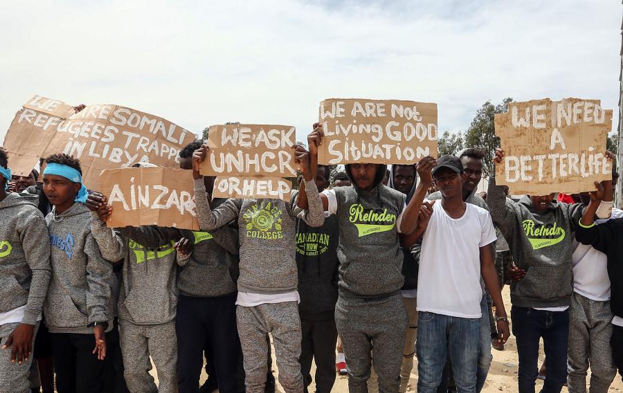 Tripolis, Libyen, 04.04.2019: Während eines Besuchs von UN-Generalsekretär Antonio Guterres im Flüchtlingslager Ain Zara in Tripolis halten Migranten Protestschilder in die Höhe.