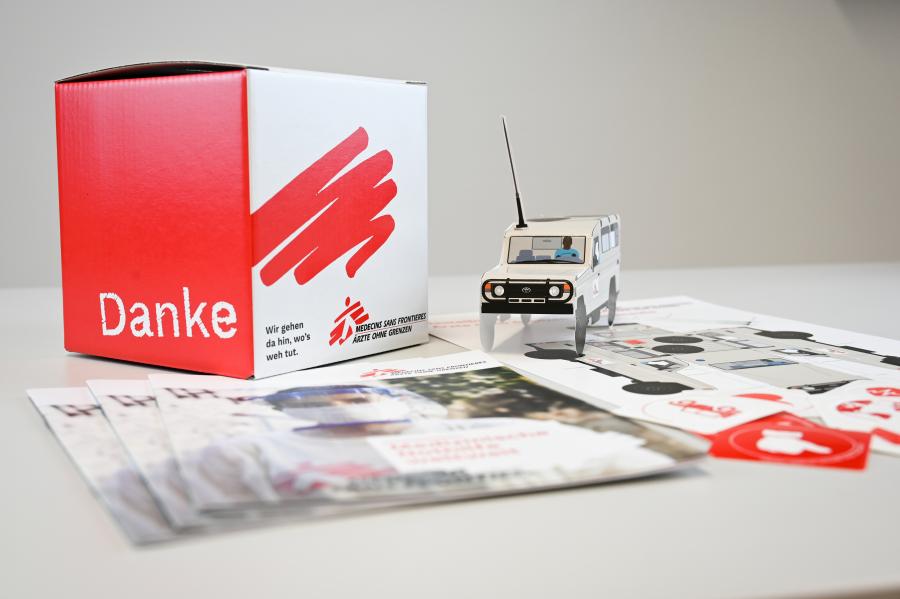 Spendenbox aus Karton, Einsatzfahrzeug, Folder und Sticker von Ärzte ohne Grenzen