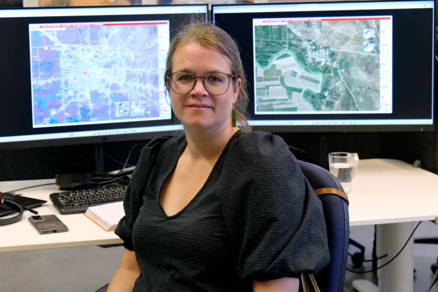 Ann De Schutter, GIS Expertin bei Ärzte ohne Grenzen, sitzt vor ihren Bildschrimen mit Satellitenbildern