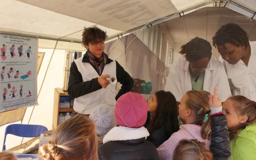 Krankenpfleger Florian Blaser führt eine Schulklasse durch die Ausstellung „Hilfe aus nächster Nähe“