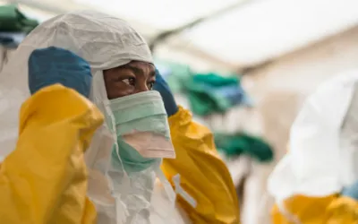 Bevor die medizinischen Teams im Isolationsbereich Ebola-PatientInnen versorgen können, muss die entsprechende Schutzkleidung angelegt werden.
