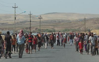 Flüchtlinge von Sindschar marschieren über die syrische Grenze in den Irak.