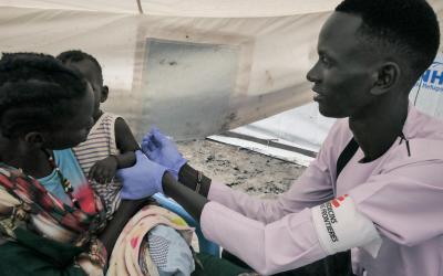 MSF Nurse Gatwech Tuoch immunizes a child against measles
