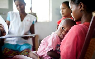A mother and child sitting for a checkup at Pusalota health centre.