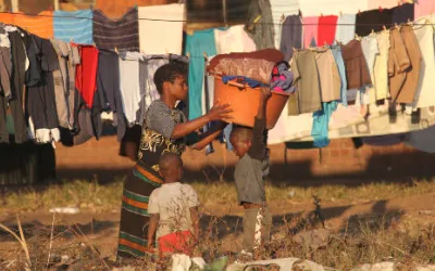 Alltgasszene in Mbare, eine Frau hängt die Wäsche auf