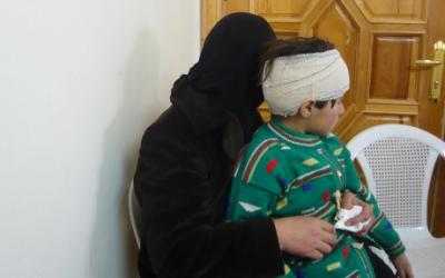 Syrisches Mädchen mit Kopfverband und ihre Mutter
