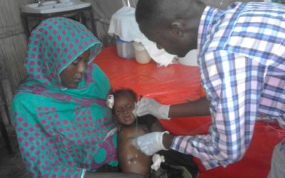 White Nile State, Sudan, Doctor examines child