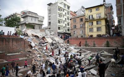 Menschen suchen in den Trümmern eines eingestürzten Hauses nach Überlebenden  nach einem Erdbeben. 