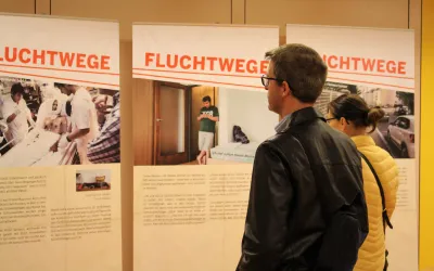BesucherInnen sehen sich die Ausstellung Fluchtwege von Ärzte ohne Grenzen an.