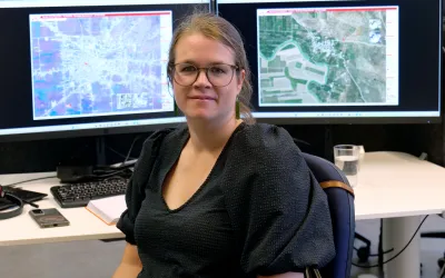 Ann De Schutter, GIS Expertin bei Ärzte ohne Grenzen, sitzt vor ihren Bildschrimen mit Satellitenbildern