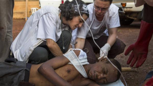 Ein Team von Ärzte ohne Grenzen versorgt im Vertriebenenlager am Flughafen einen verwundeten Mann.
