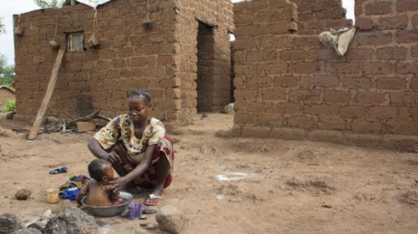 Eine Frau mit ihrem Kind vor zerstörten Häusern im Dorf Zere in der Zentralafrikanischen Republik, eine ca. 2-stündige Fahrt von Bossangoa entfernt.