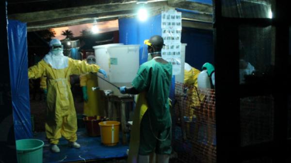 Medizinisches Personal bei der Desinfektion von Schutzkleidung im Ebola-Behandlungszentrum in Foya.