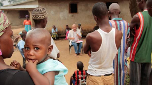 Der Epidemiologie Michel Van Herp von Ärzte ohne Grenzen (Bildmitte) erklärt der lokalen Bevölkerung in Gbando die Krankheit Ebola und wie man eine Ausbreitung des Virus vermeiden kann.