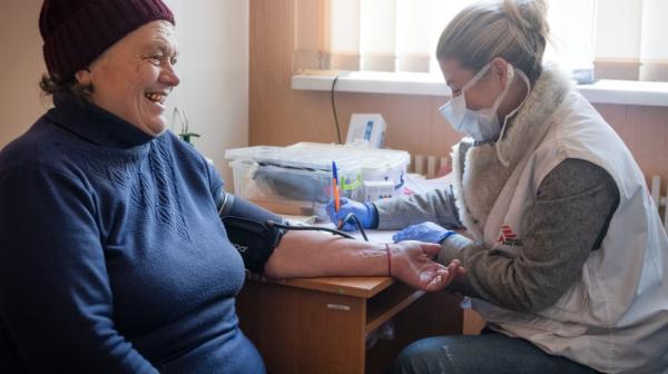 MSF doctor Olena Kurinna checking Anna Ivanivna Nefedova's blood pressure