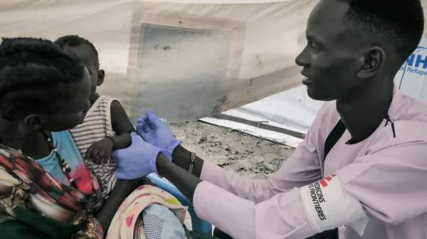 MSF Nurse Gatwech Tuoch immunizes a child against measles