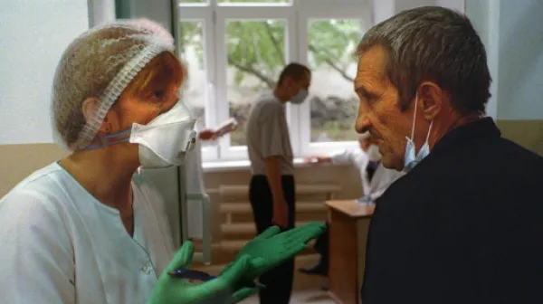 Eine Krankenschwester versucht einen Patienten mit medikamentenresistenter Tuberkulose zu überzeugen, seine tägliche Medikation weiter einzunehmen.