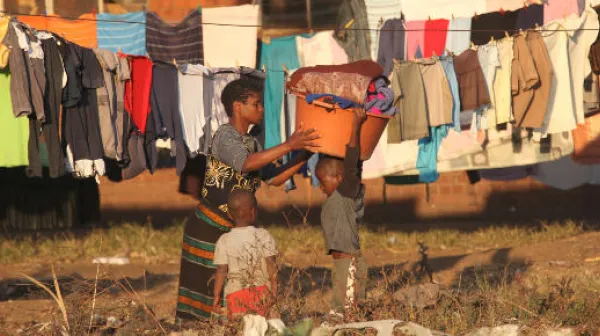 Alltgasszene in Mbare, eine Frau hängt die Wäsche auf