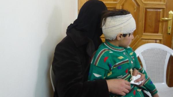 Syrisches Mädchen mit Kopfverband und ihre Mutter