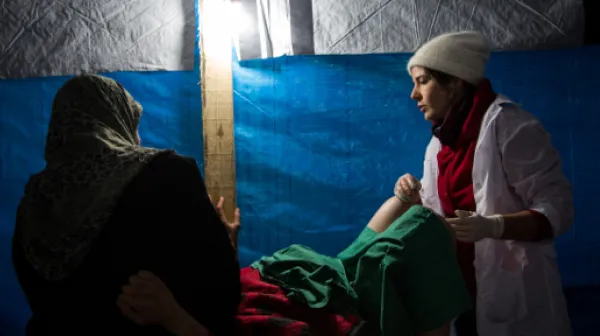 Hebamme Cathy Janssens beruhigt ihre Patientin und hilft bei der Geburt des Babys.