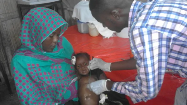 White Nile State, Sudan, Doctor examines child