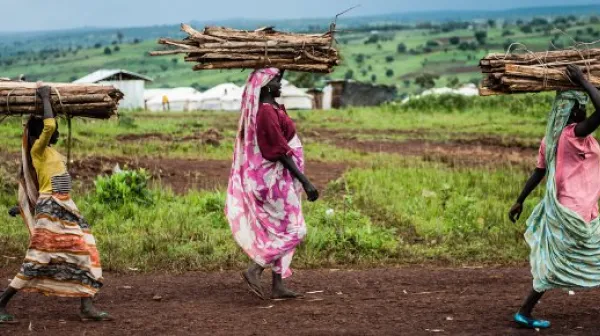 Frauen tragen Gehölz durch das Lager Bambasi.