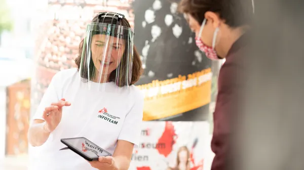 Mitarbeiterin im Gespräch an unserem Informationsstand