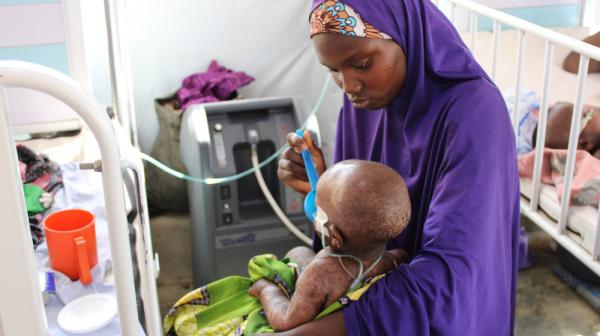 Ein schwer an Masern erkranktes Kind wird im von Ärzte ohne Grenzen unterstützten Spital in Anka im Bundesstaat Zamfara in Nigeria medizinisch versorgt. 