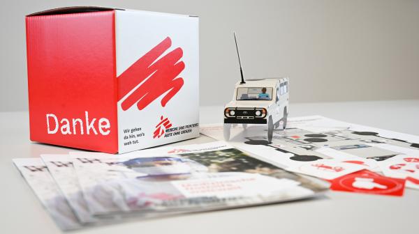 Spendenbox aus Karton, Einsatzfahrzeug, Folder und Sticker von Ärzte ohne Grenzen