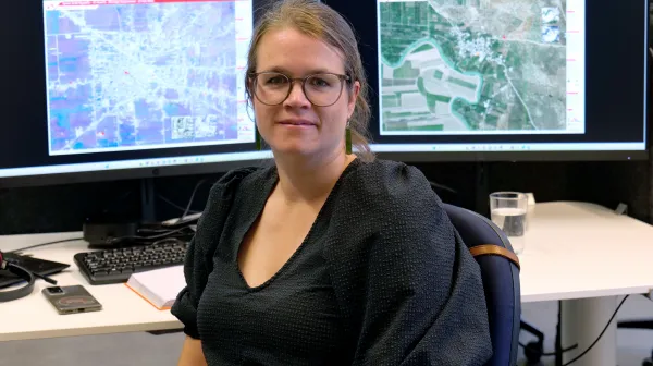 Ann De Schutter, GIS Expertin bei Ärzte ohne Grenzen, sitzt vor ihren Bildschrimen mit Satellitenbildern