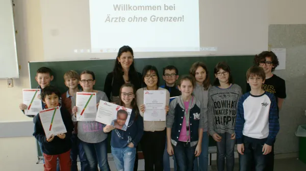 Schüler zeigen Ihre Urkunde und das MUAC-Band zum Ausschneiden